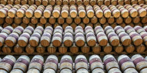Fileiras de barris de carvalho empilhados para envelhecimento do vinho em uma vinícola espanhola.